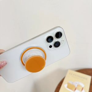 Detailed view of an orange magnetic folding phone socket stand being held on a smartphone
