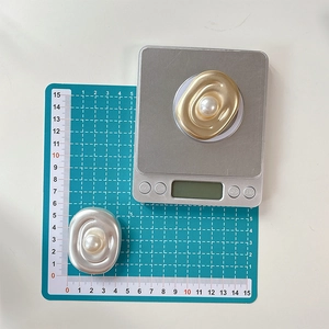 Detailed size measurement of the oval pearl MagSafe phone stand on a digital scale