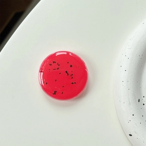 Macro shot of translucent cherry red resin phone socket with black flecks and glossy finish
