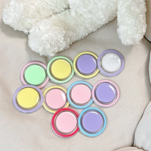 Colorful Macaron palette of solid nail gel containers on soft fabric background