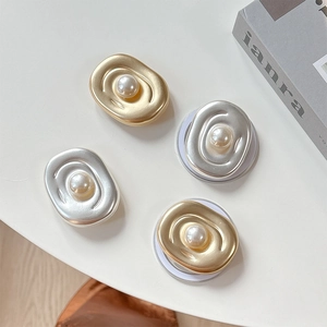 Oval metallic pearl phone grip sockets in gold and silver finishes on a desk