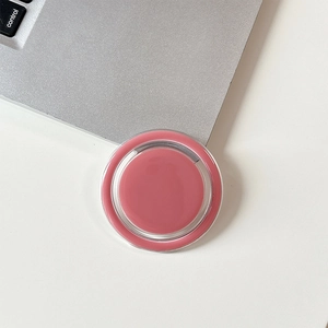 Close-up of solid balm compact in soft dusty pink on minimalist white desktop surface