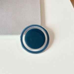 Macro view of a dark blue solid gel makeup product in a round transparent container