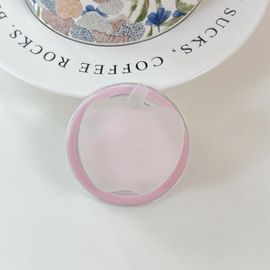 Dettaglio dell'impugnatura per telefono rosa a forma di mela su tavolo con piatto decorativo