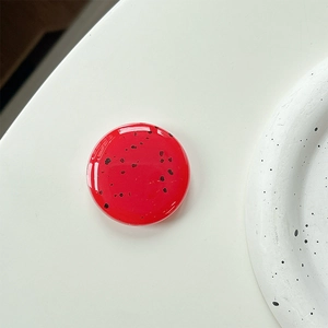 Detail shot of a round red watermelon pattern phone grip with a glossy resin finish
