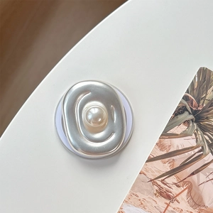 Detailed view of silver oval metal phone grip featuring a large central white pearl