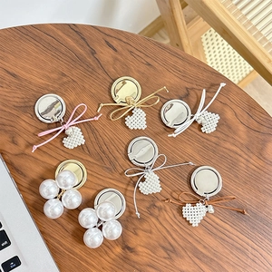 Elegant heart pearl bow phone ring stand assortment on a rustic wooden background