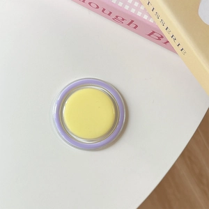 Detail of a round magnetic phone grip with yellow and purple candy color resin finish
