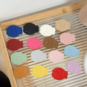 Fish-shaped leather phone grips in 15 vibrant colors with premium embossed texture