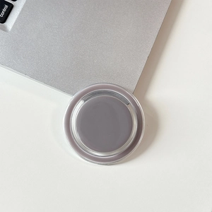 Close-up of a Morandi gray magnetic MagSafe phone grip on a white desk surface