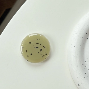 Detail of green resin phone grip with black stone fragments and smooth glossy finish