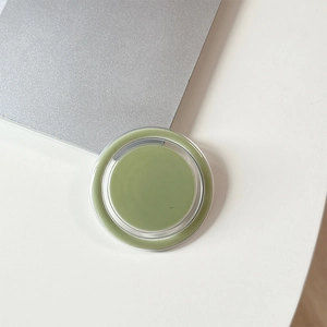 Detail of a minimalist round magnetic phone grip in fresh pastel green finish