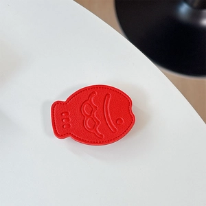 Detail of red fish leather phone socket with lychee grain texture and stitching