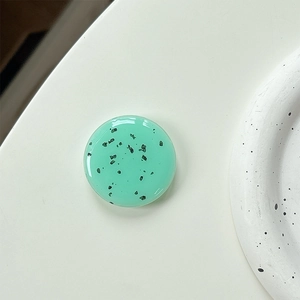 Macro view of mint green round phone socket with black speckles and glossy finish