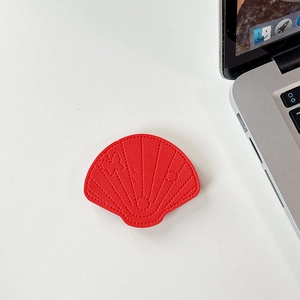 Close-up of red leather shell-shaped phone grip with embossed butterfly details