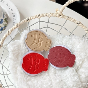 Three leather fish-shaped phone socket grips in red and brown with lychee grain texture