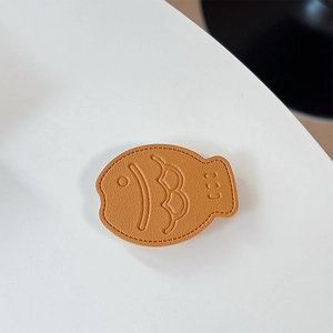 Macro shot of caramel leather taiyaki phone socket with detailed stitching and texture