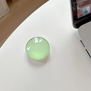 Detailed view of a light green crystal glass circular expandable phone socket grip
