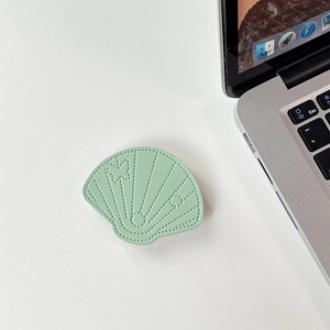 Detail of mint green shell-shaped phone stand with elegant faux leather stitching