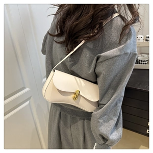 Close-up of a white leather half-moon shoulder bag featuring a gold rotating metal buckle