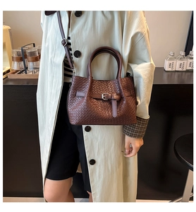 Détail du sac seau en cuir tressé marron foncé avec poignée et bandoulière réglable