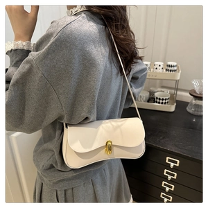 Detail of white faux leather shoulder bag featuring a sleek golden oval twist-lock buckle