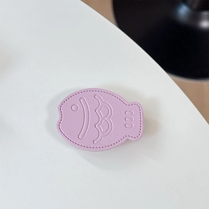 Close-up of lavender leather fish-shaped phone grip with detailed scale stitching