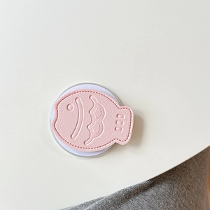 Detailed view of pink leather fish phone socket with embossed scales and clear base