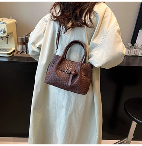 Vue détaillée d'un sac à main tissé marron foncé avec boucle en métal et bandoulière