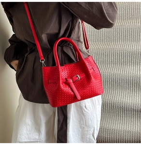 Détail du sac seau rouge tissé avec boucle métallique et bandoulière amovible