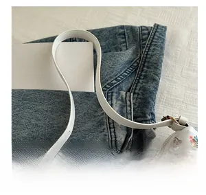 Close-up of floral print underarm bag featuring white leather texture and gold hardware
