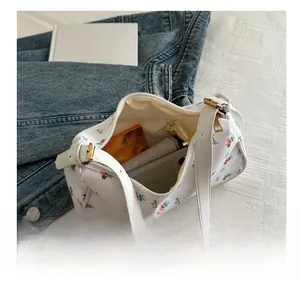 Floral canvas shoulder bag showing interior capacity for phone and cosmetics