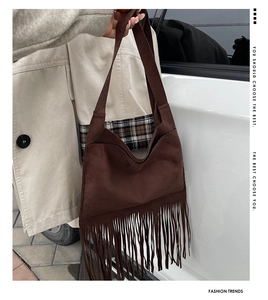 Detail der dunkelbraunen Wildleder-Schultertasche mit langen Fransen und breitem Gurt
