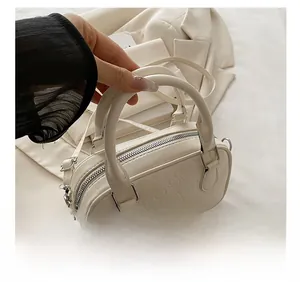 Detail of cream bowling bag with embossed heart patterns and silver-tone hardware