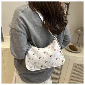 Détail du sac à bandoulière blanc à fleurs avec motifs colorés et fermeture zippée