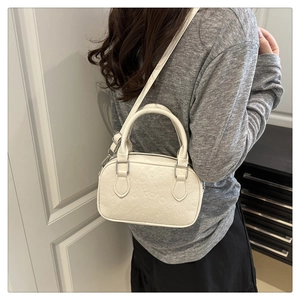 Close-up of white embossed PU leather crossbody bag with cartoon motifs and silver buckles