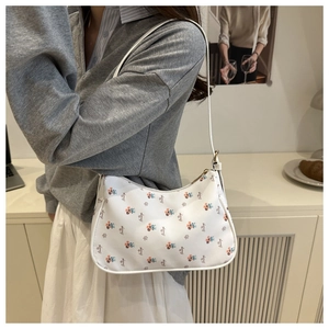 Détail du sac à bandoulière à imprimé fleuri avec fermeture éclair sur un mannequin