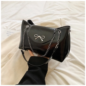 Black glossy leather tote bag with silver bow accent and chain strap for women