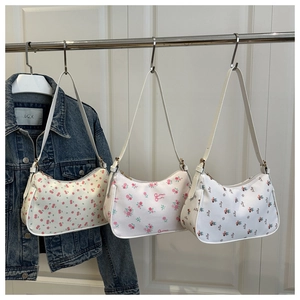 Detailed view of three floral print hobo shoulder bags with cherry and rose patterns