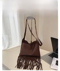 Detail der kaffeebraunen Wildleder-Tragetasche mit langen Fransen in Lifestyle-Umgebung