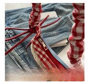 Detail of red gingham and denim patchwork handbag with lace trim and smooth zipper