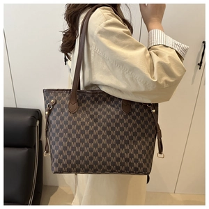Detail of dark brown tote bag with M letter print and gold pendant decoration