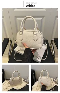 Detail of white PU leather bowling bag featuring embossed patterns and double handles