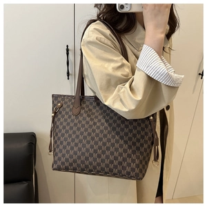 Detail of vintage brown tote bag with M-pattern print and side decorative drawstrings