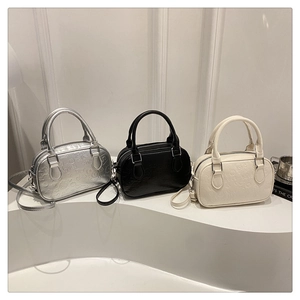 Detailed close-up of retro embossed bowling handbags in silver, black and white faux leather