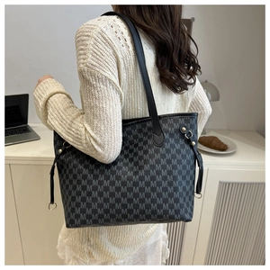 Detail of large tote bag with M-letter jacquard pattern and black shoulder straps