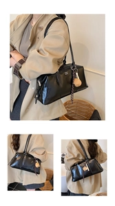 Nahaufnahme einer schwarzen Boston-Tasche mit weißem Schriftzug und Herz-Anhängern