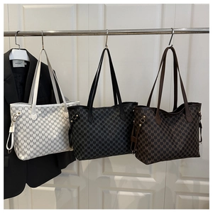 Detailed display of tote bags in black, white and brown with all-over M-letter patterns