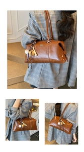 Detailansicht der braunen Vintage-Glanzledertasche mit modischem Baseball-Anhänger-Detail