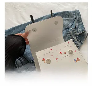 Détails du sac à main blanc avec boucles magnétiques argentées et motifs de chiens